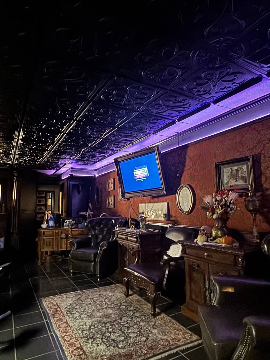 Lounge at Classic Barber Shop in Lansing with black tin ceiling and antique furniture